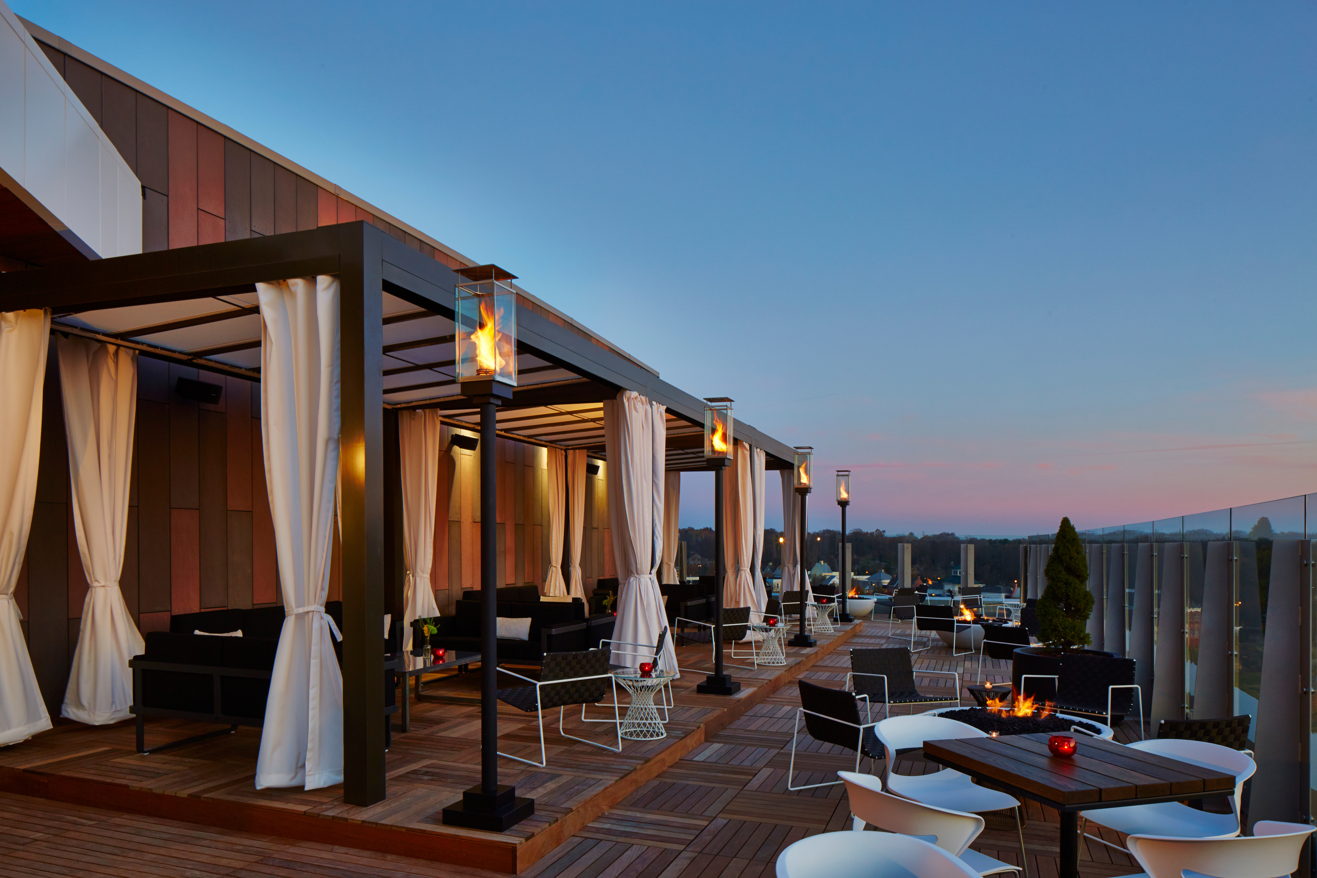a patio with a fire pit and chairs