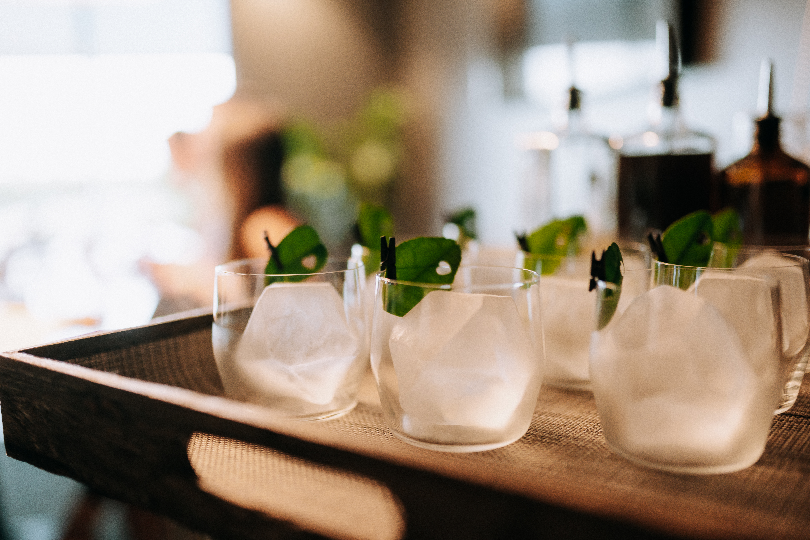 a group of glasses with ice and leaves on them