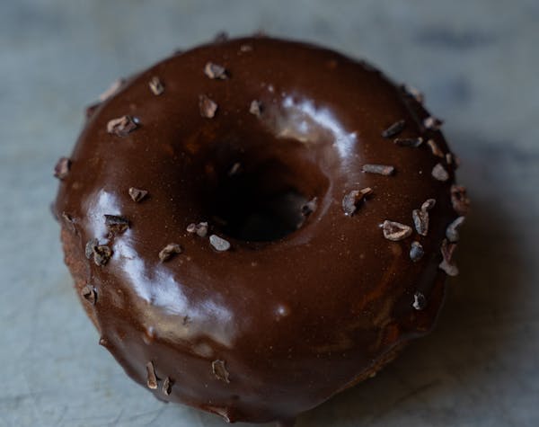 a hand holding a chocolate donut