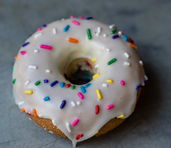 a hand holding a half eaten donut