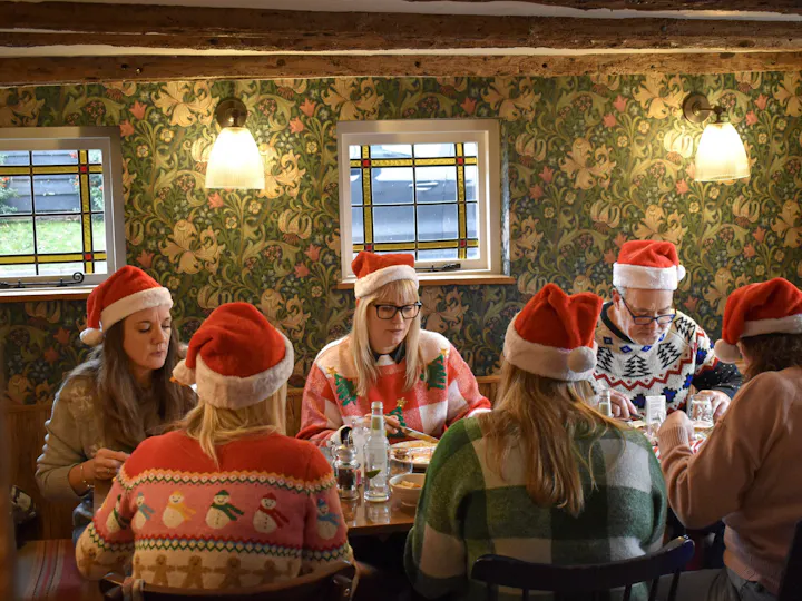 Christmas party guests in festive hats at The Fox & Hounds