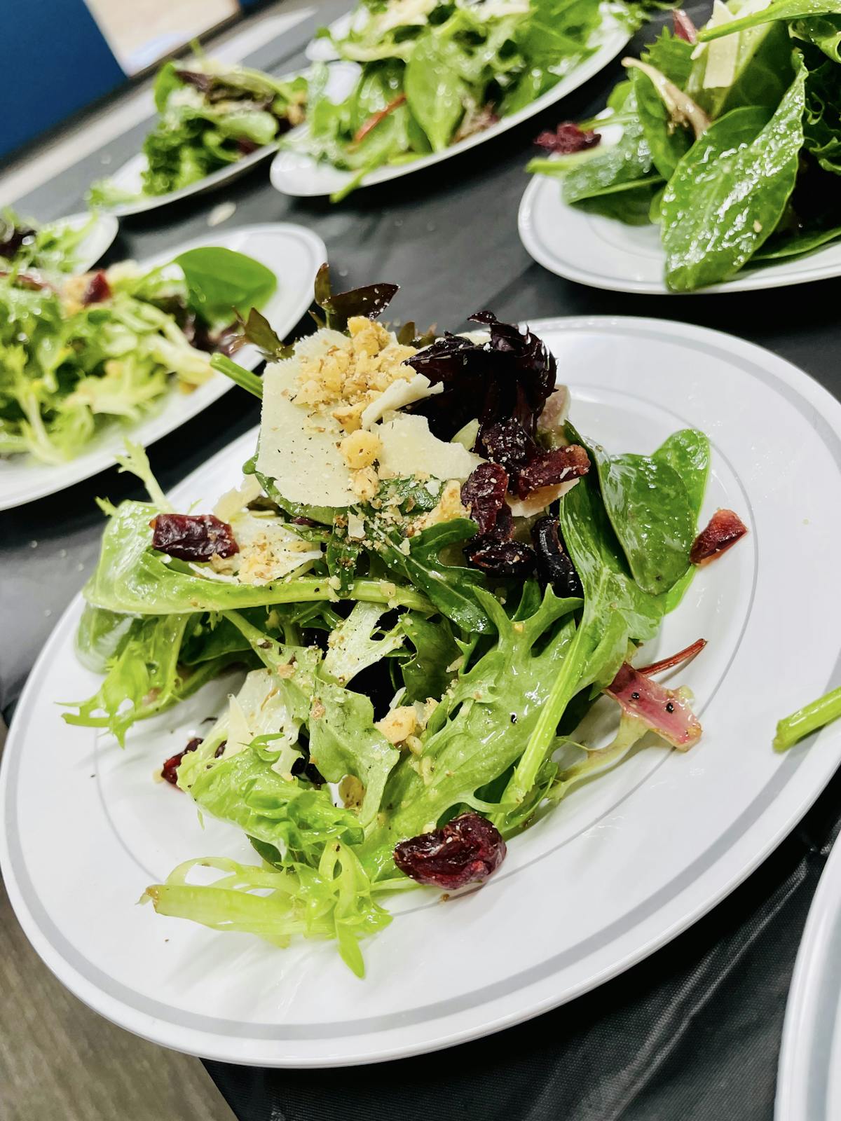 pre-plated salads that consisted of a mix filled greens, walnuts, Craisins, shaved Parmesan, cracked, play, cracked black pepper, and a house made white balsamic vinaigrette