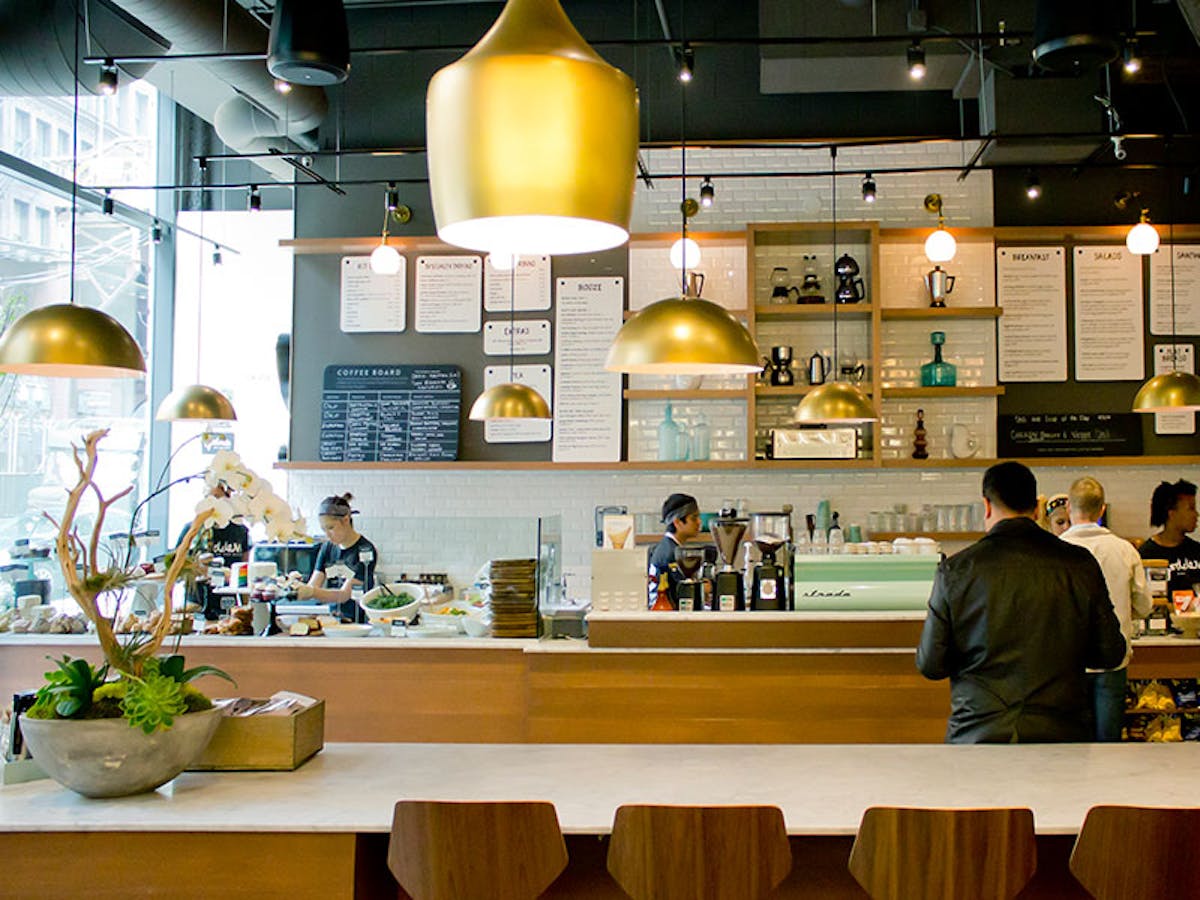 a group of people sitting at a table in a restaurant kitchen