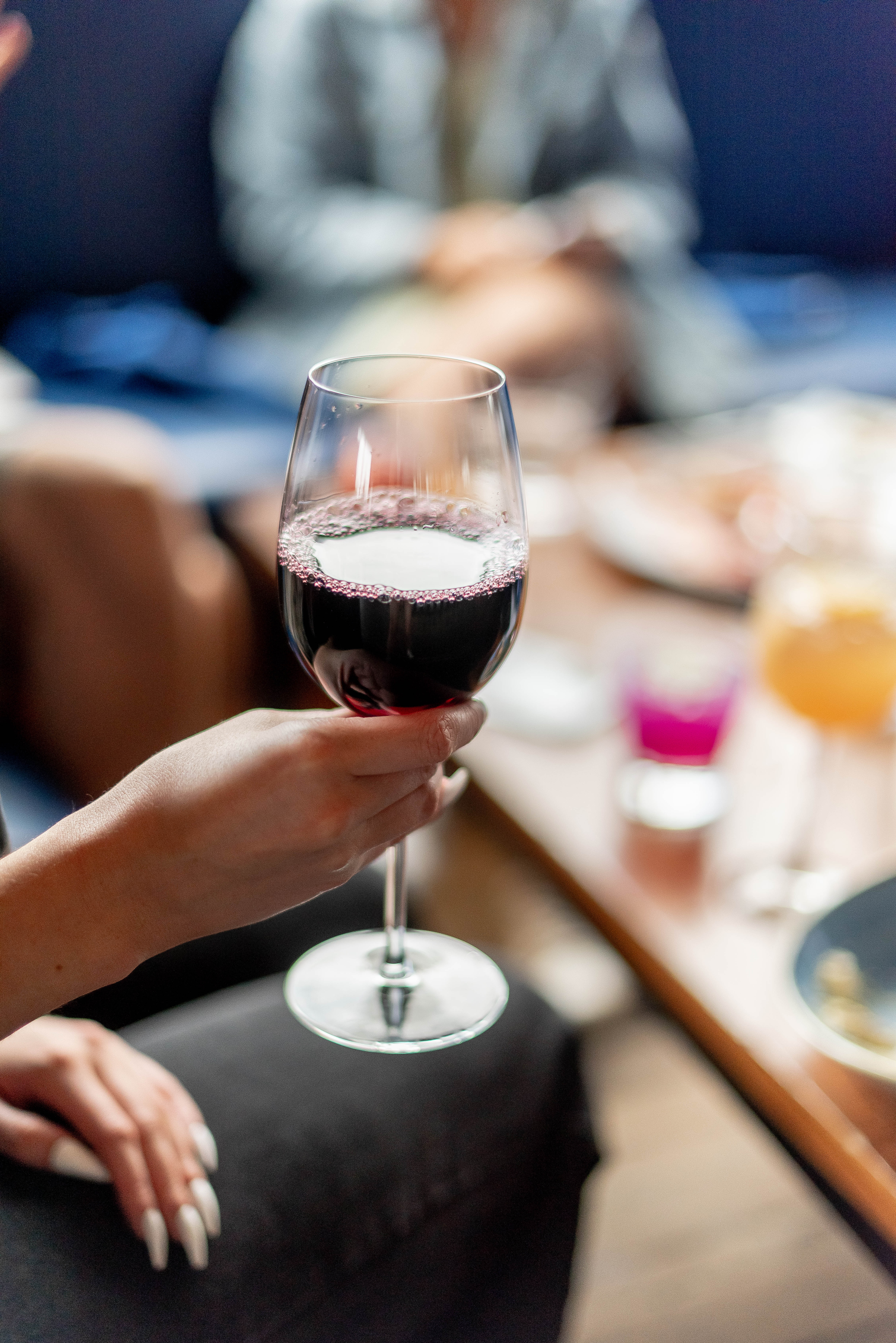 a woman sitting at a table with wine glasses