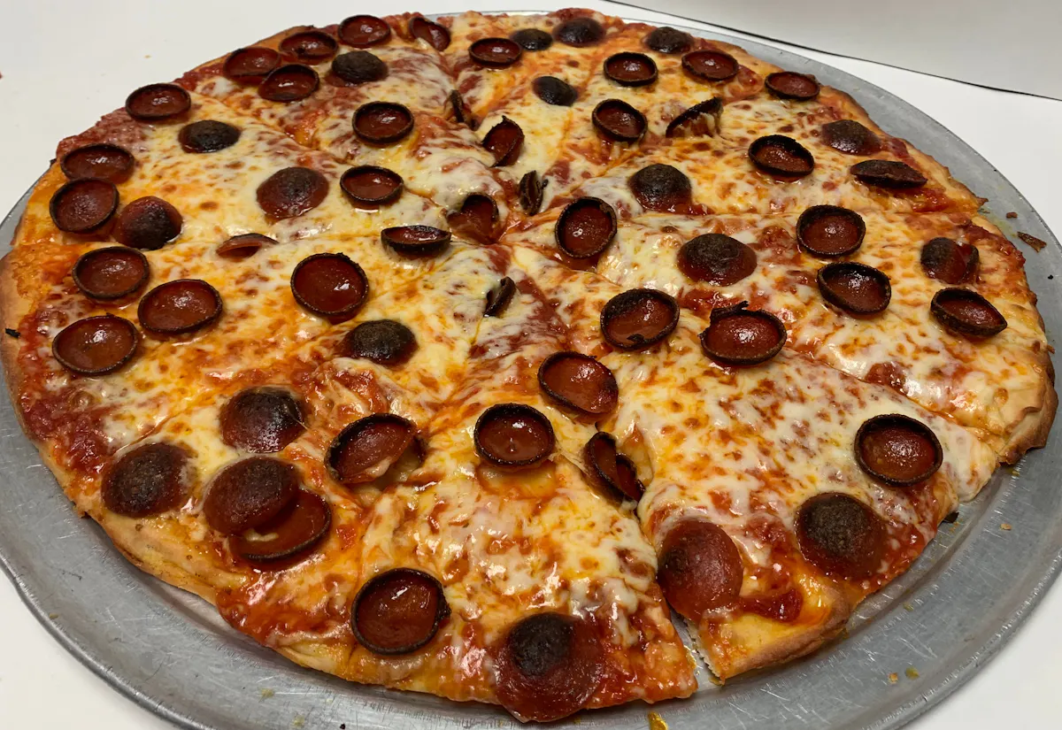 a pepperoni pizza sitting on top of a pan