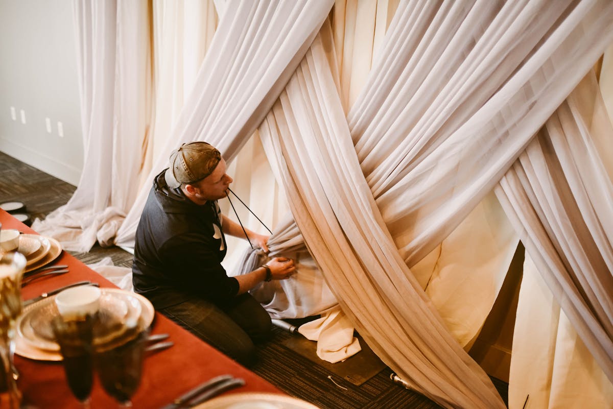 a person sitting in front of a curtain