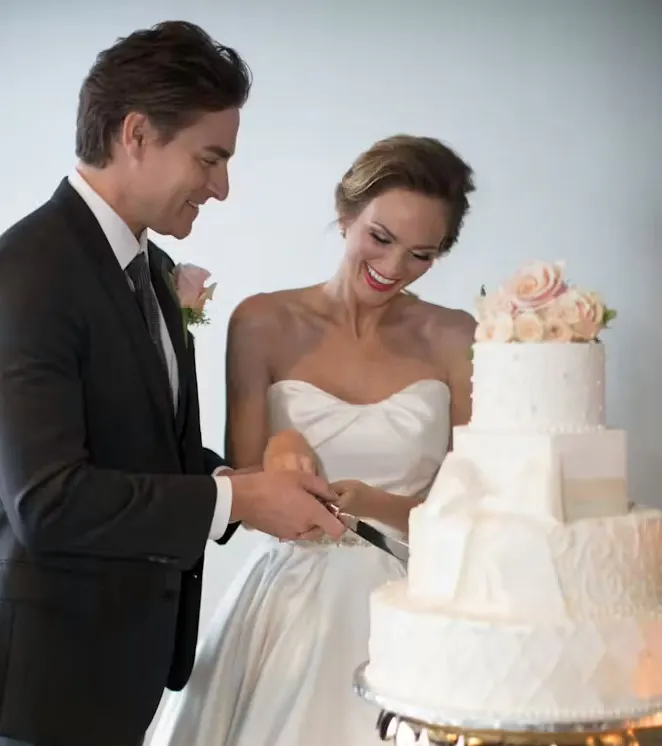 Newlywed couple cutting cake at their wedding