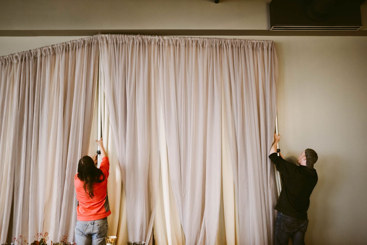 a man and a woman standing in front of a curtain