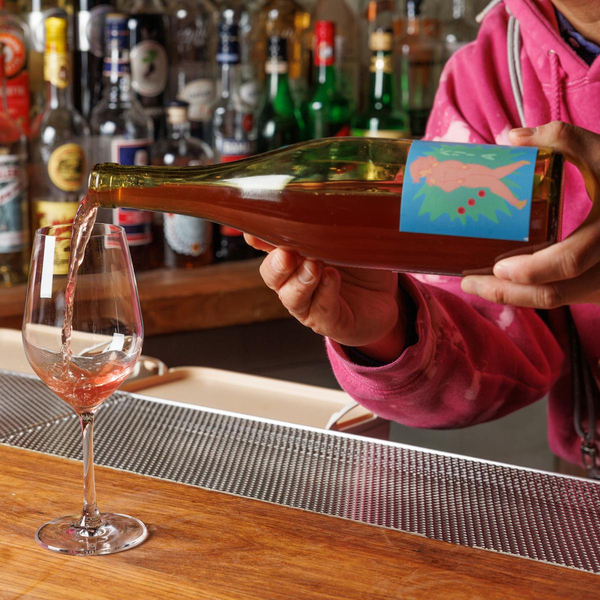 a person holding a bottle of wine on a table