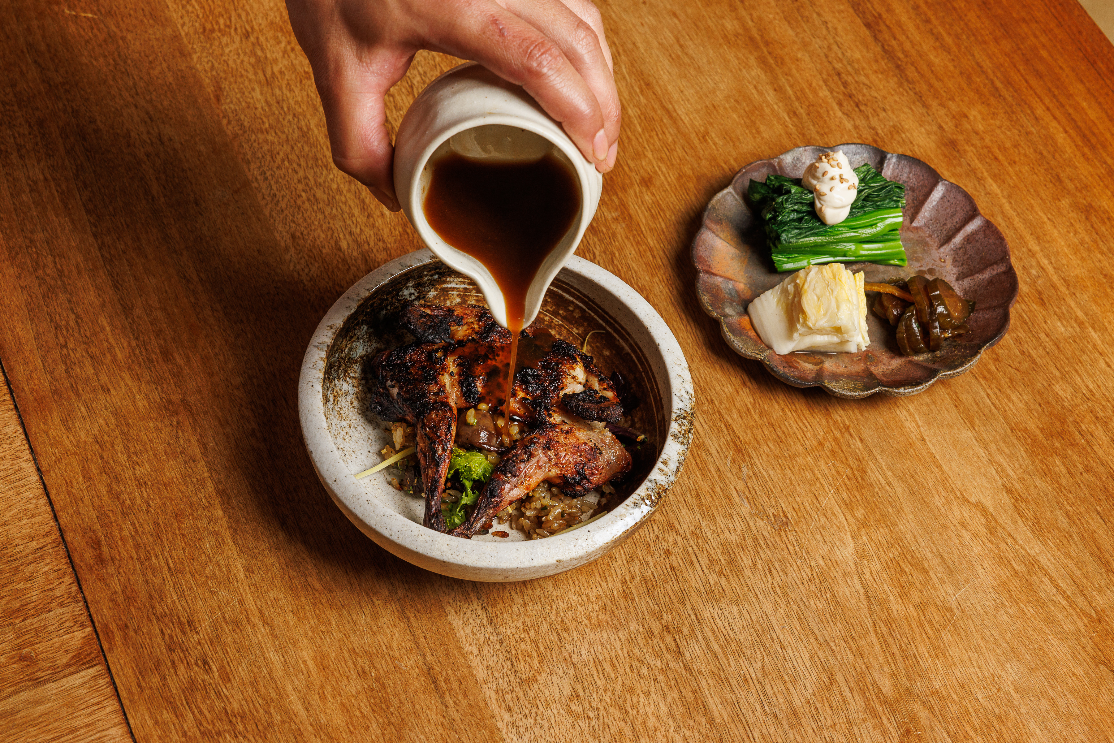 a bowl of food sitting on a wooden table