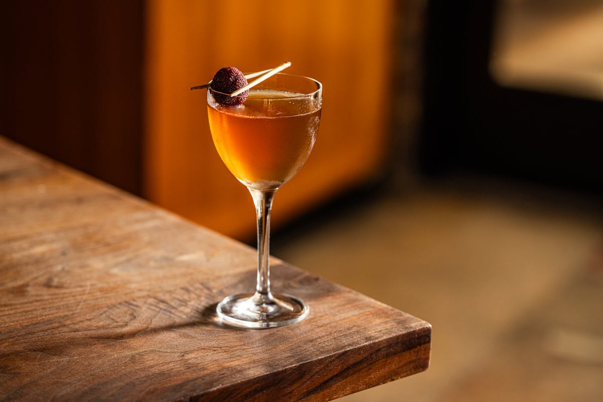 a glass of wine sitting on top of a wooden table