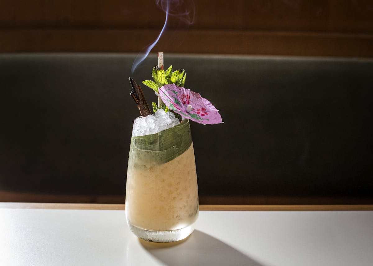 a cocktail glass filled with flowers sitting on a table