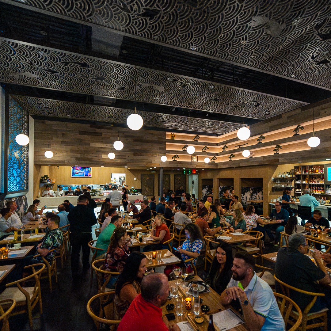 a group of people sitting at tables in a restaurant