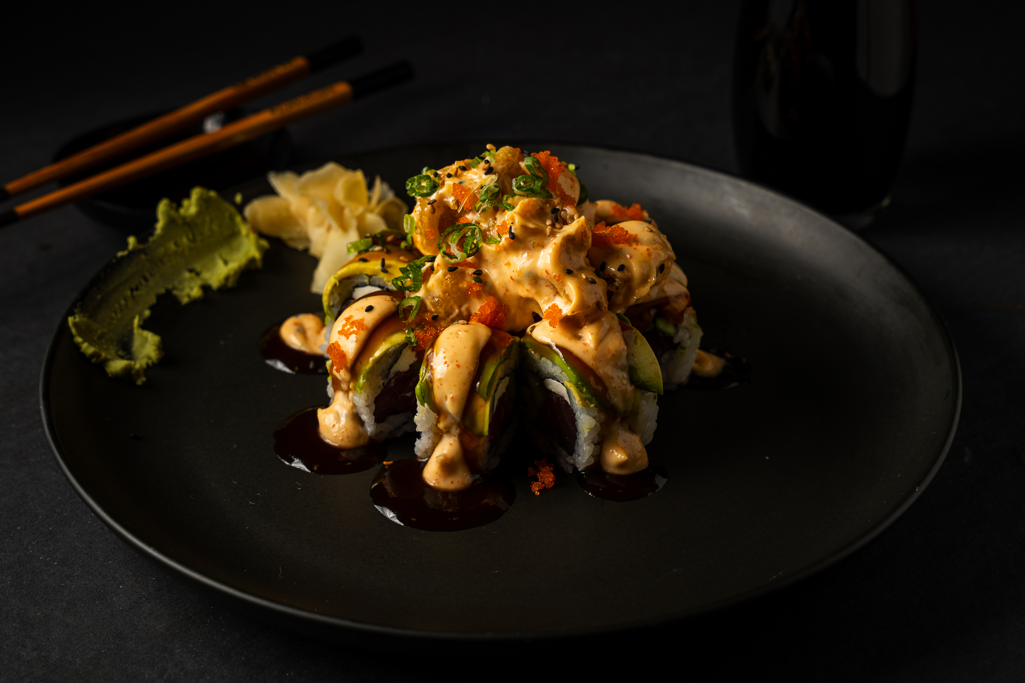 a plate of sushi with chopsticks
