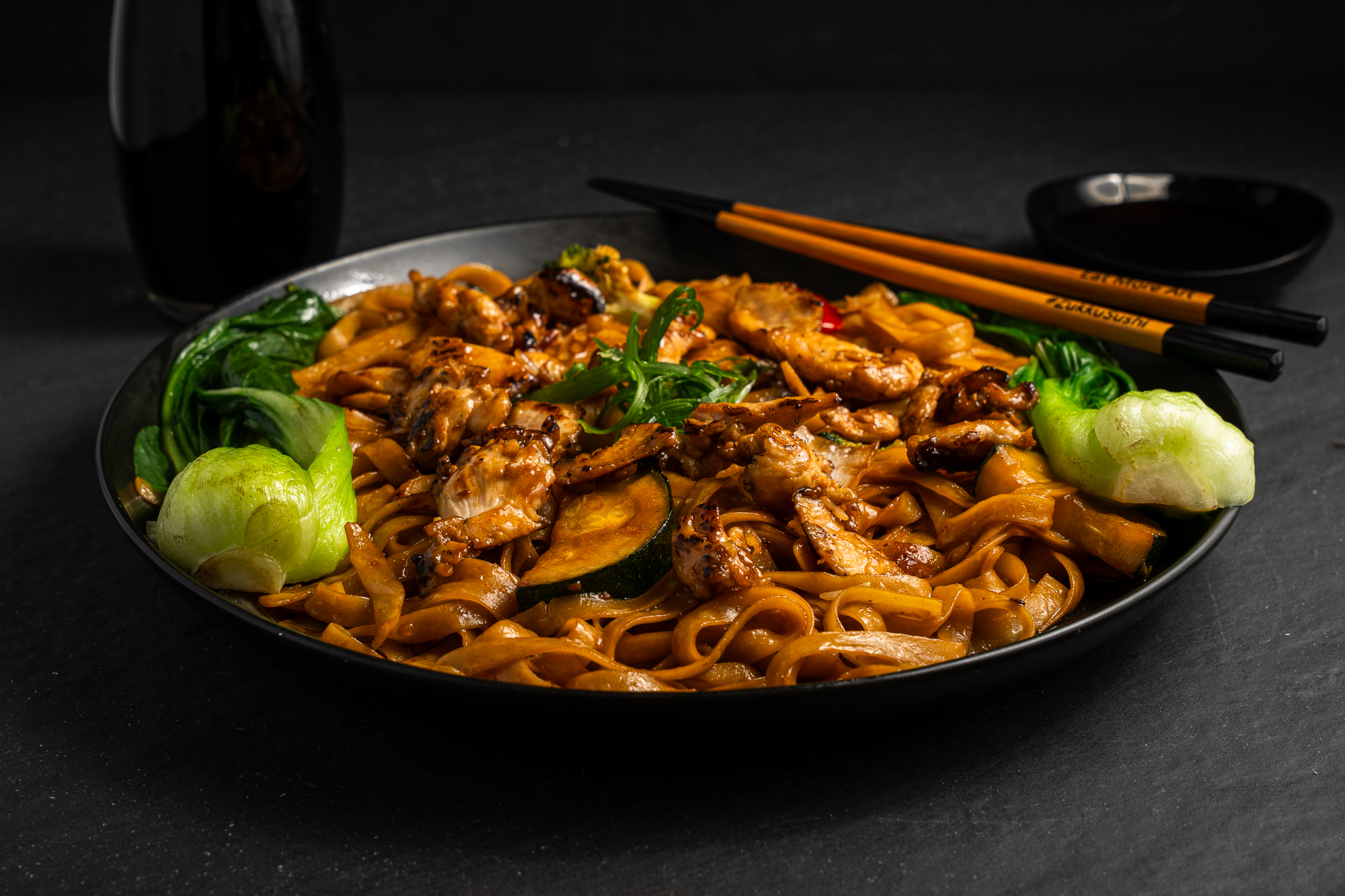 a plate of noodles with meat and vegetables