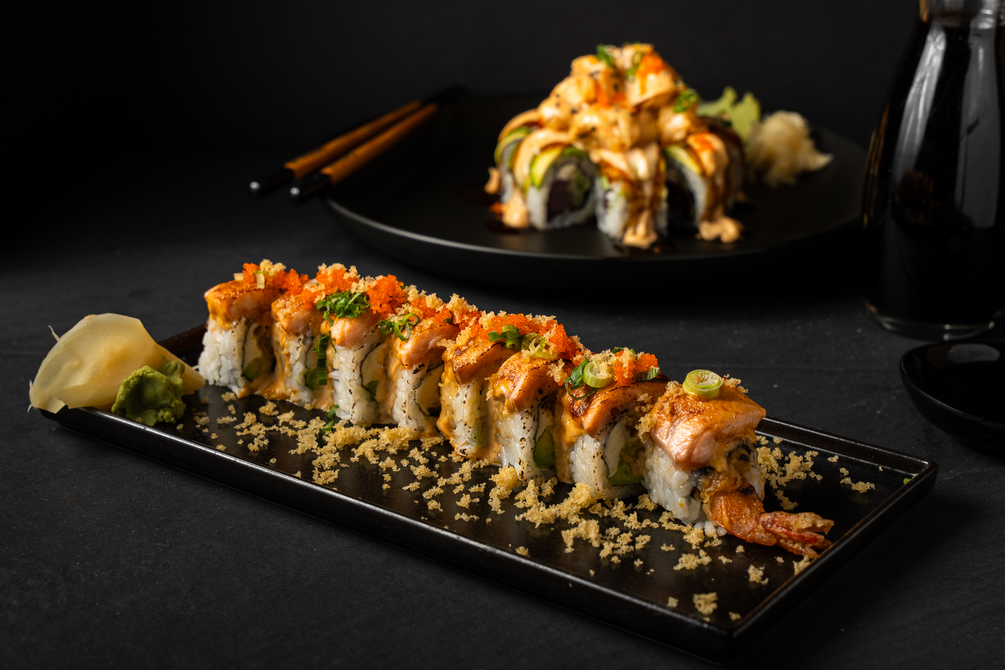 a plate of sushi with chopsticks