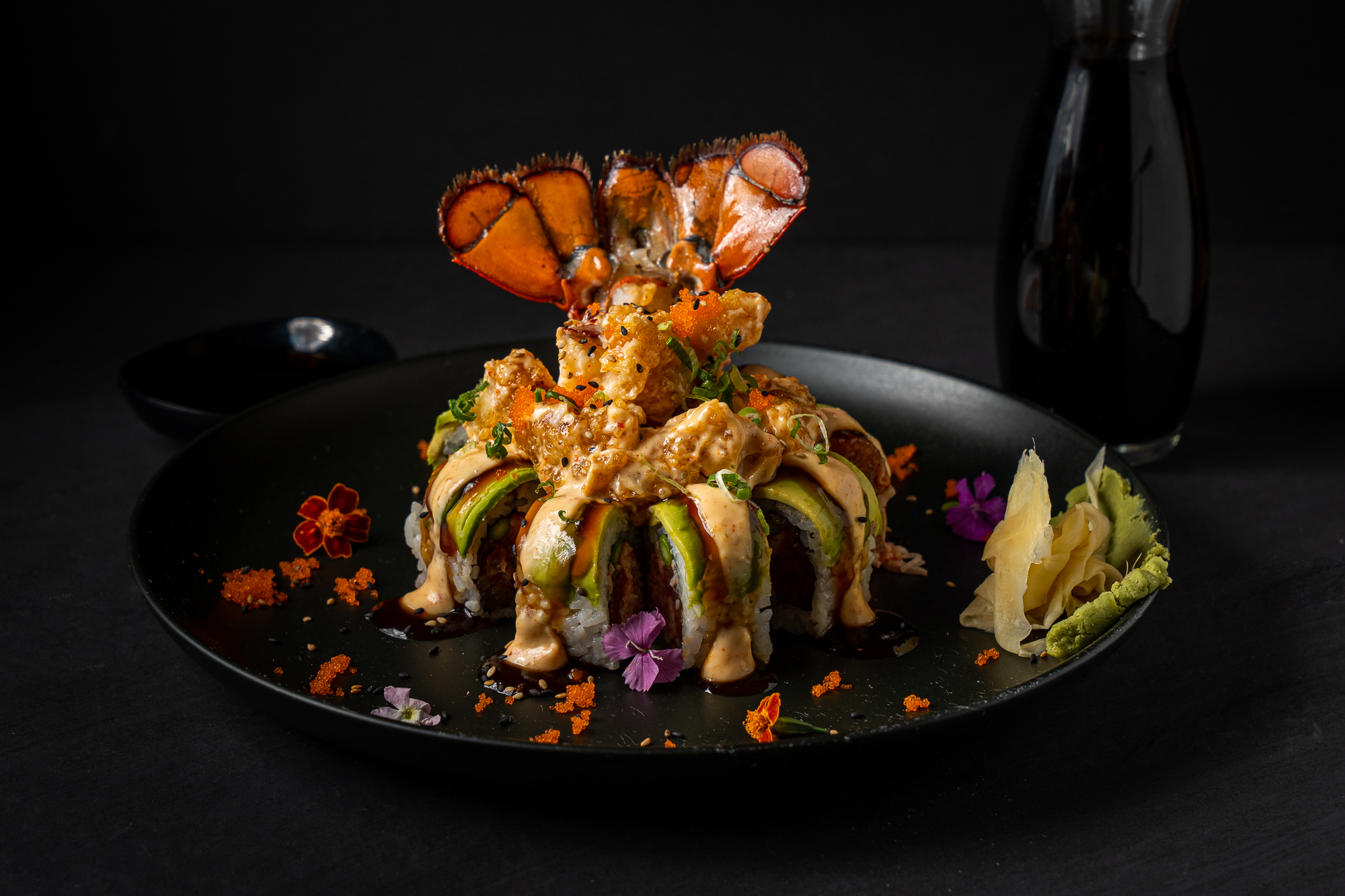 a plate of sushi with a lobster tail on top