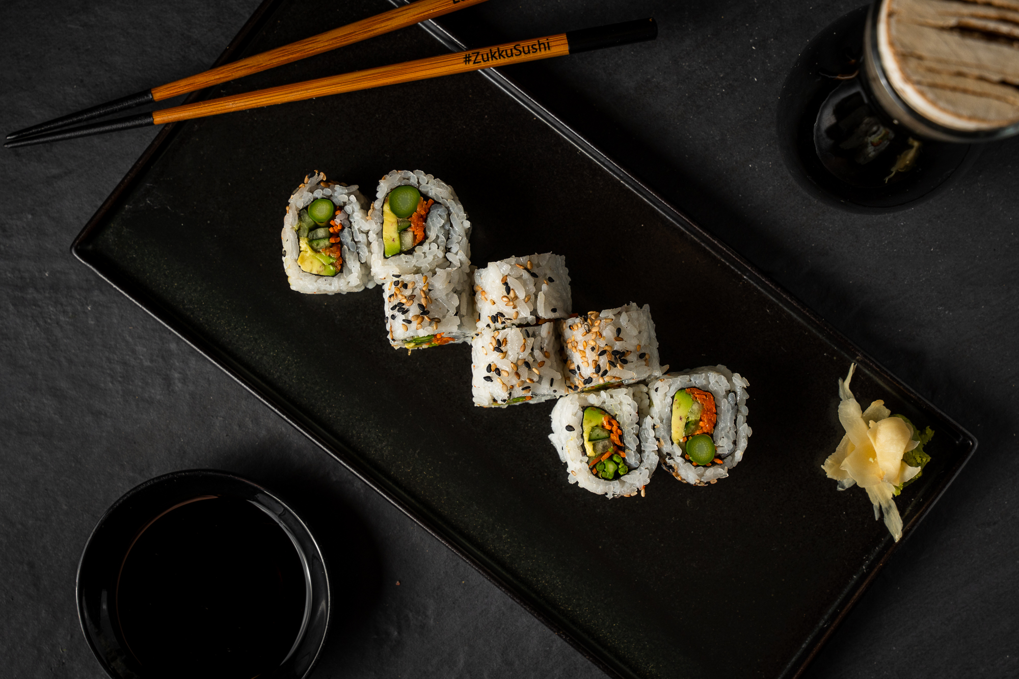 a plate of sushi and chopsticks