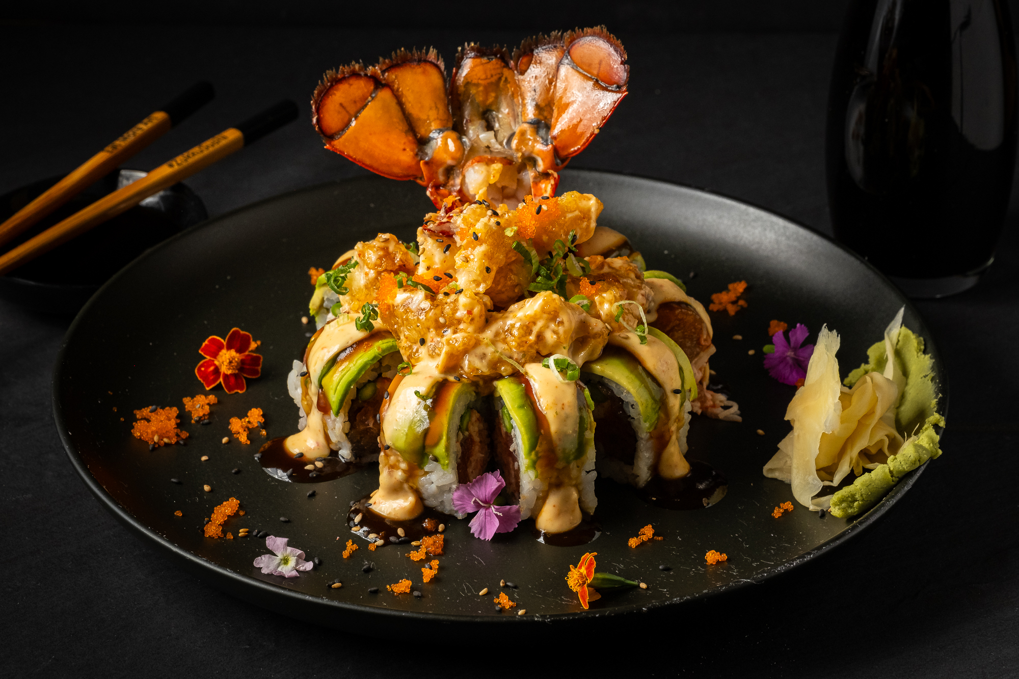 a plate of sushi with a lobster tail on top