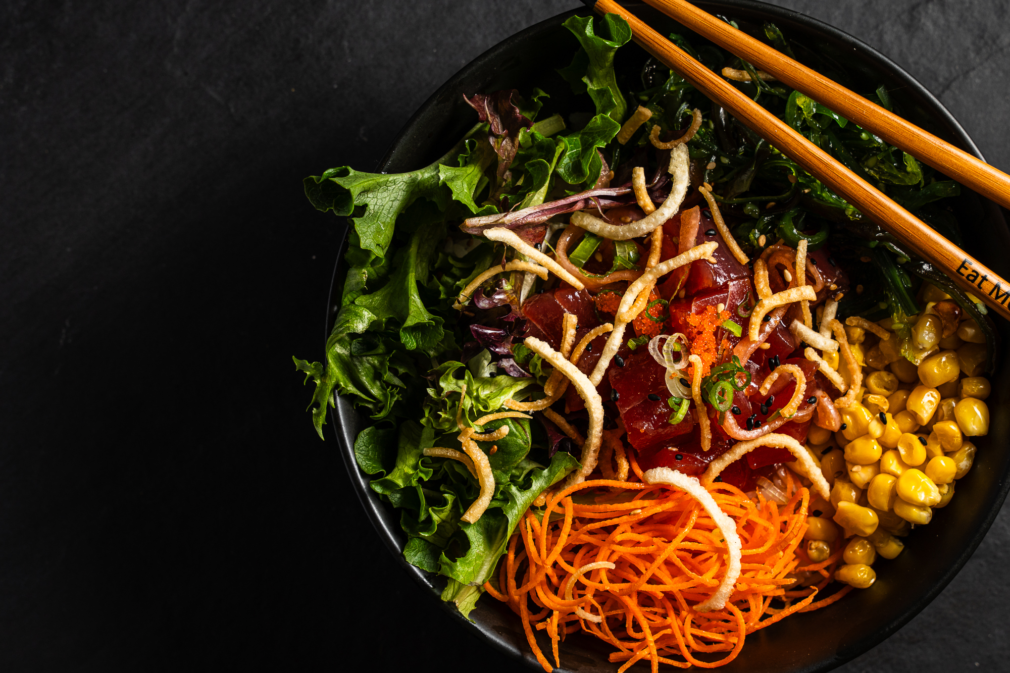 a bowl of food with chopsticks