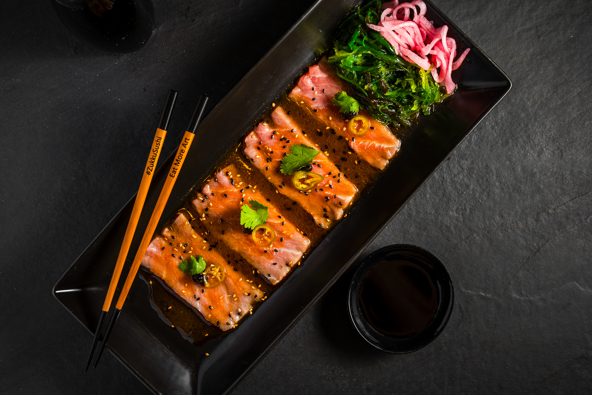 a plate of food with chopsticks and sauce