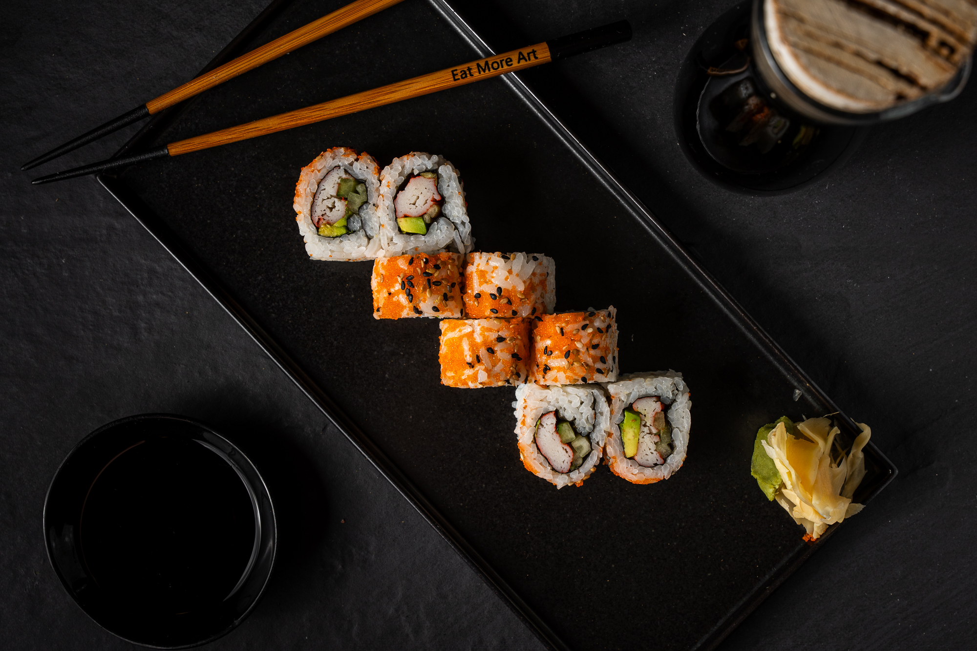 a plate of sushi and chopsticks