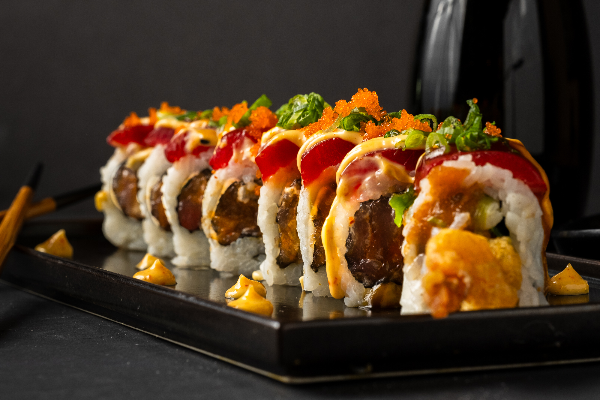 a plate of sushi on a black surface