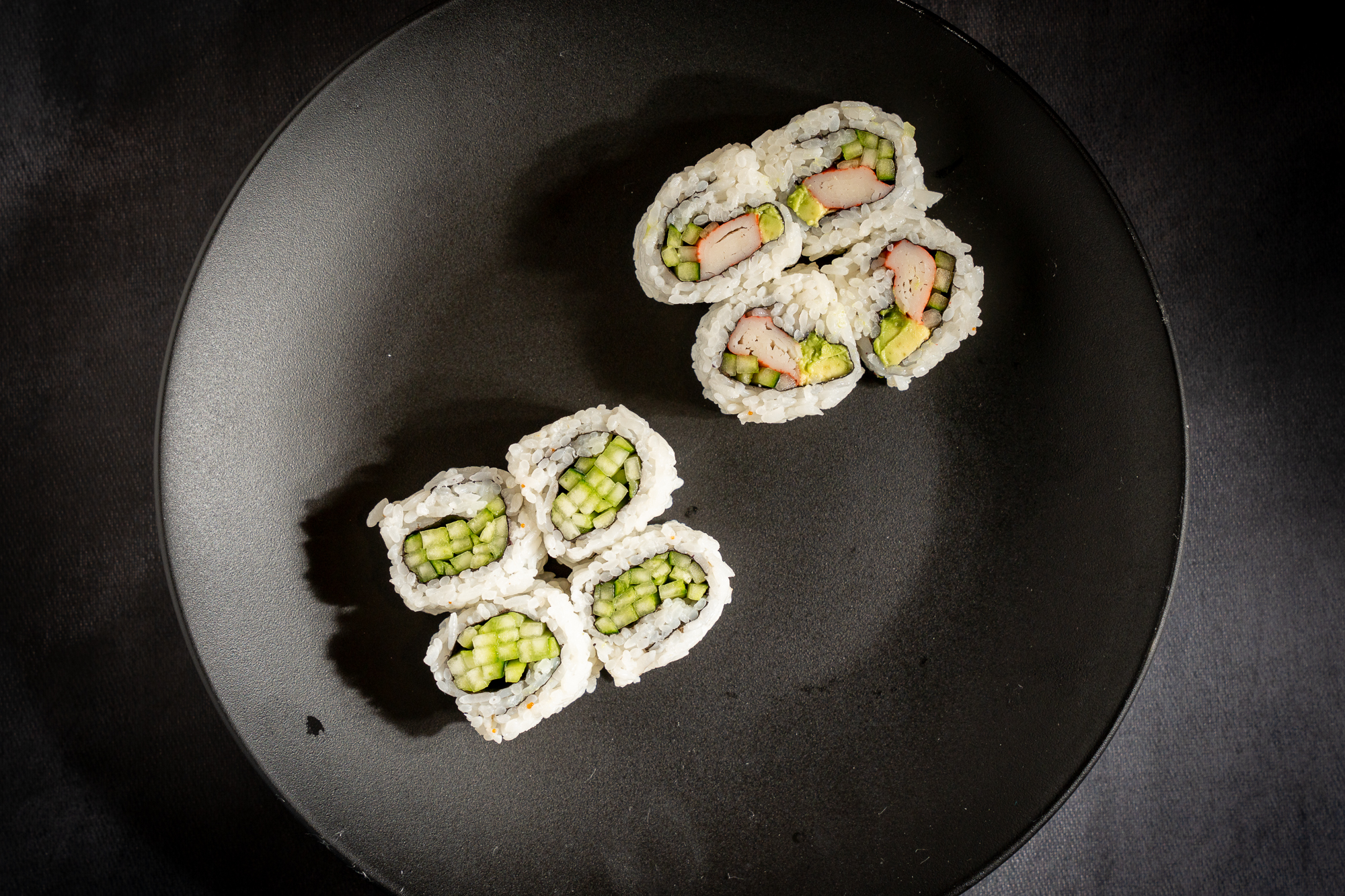a plate of sushi on a black surface