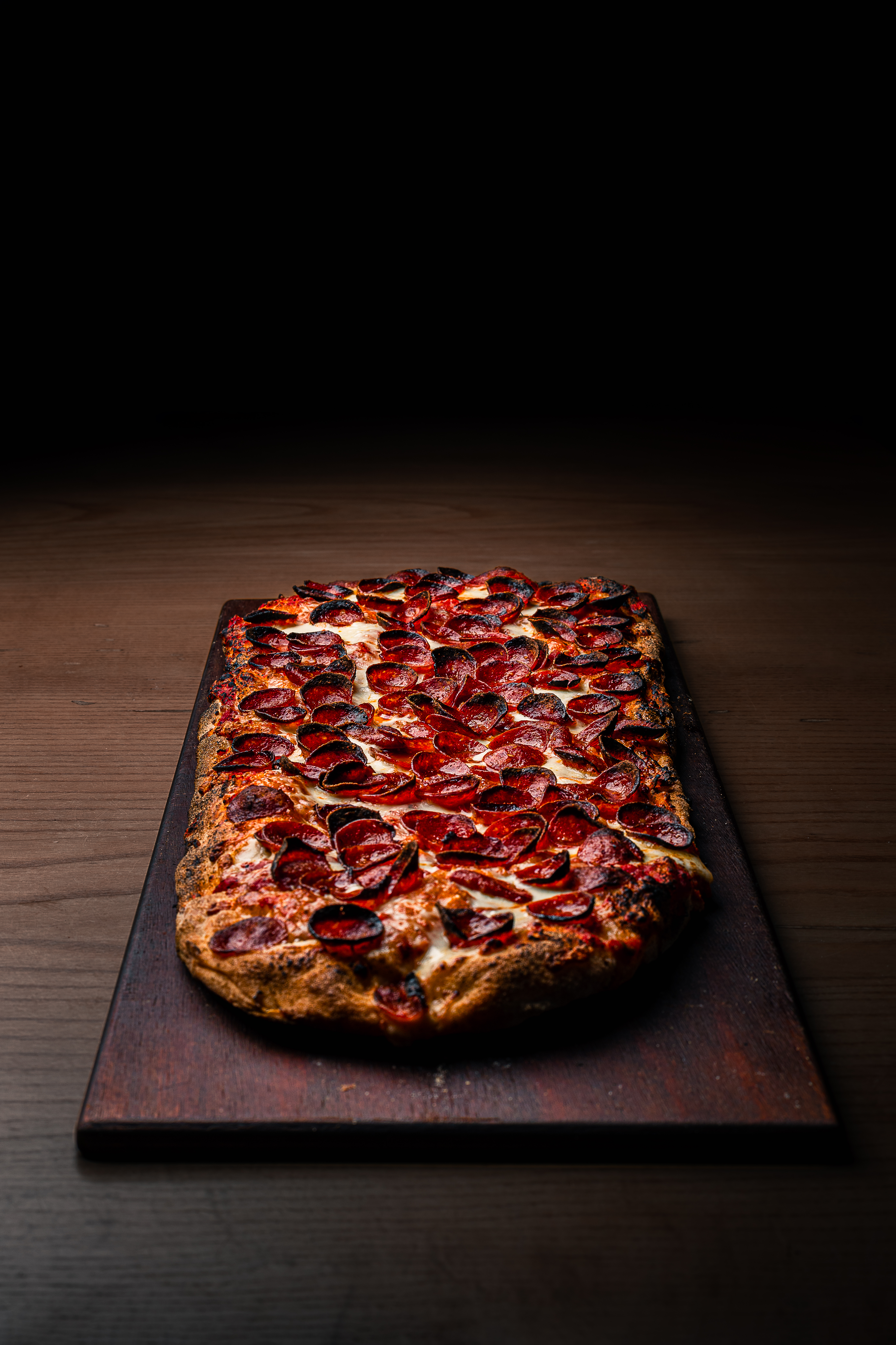 a slice of pizza sitting on top of a wooden cutting board