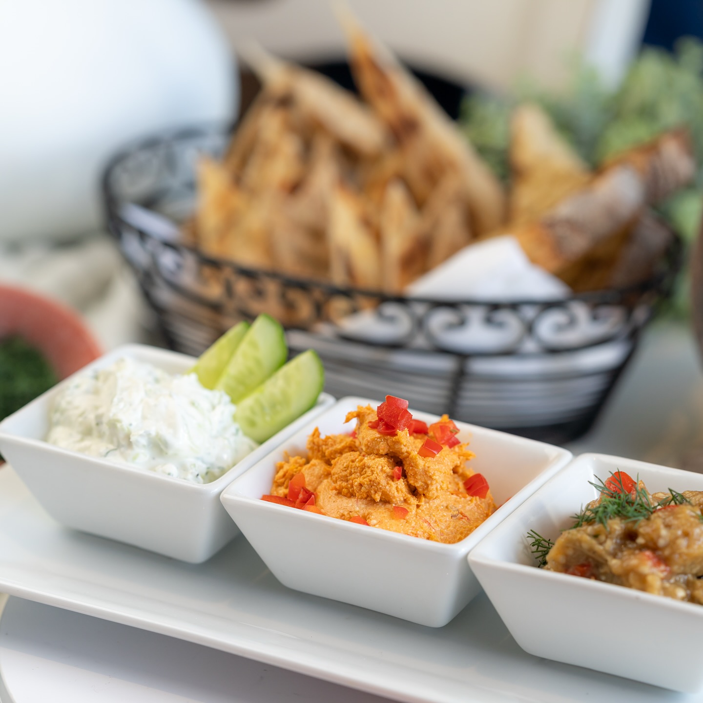 a tray of dips and a basket of bread