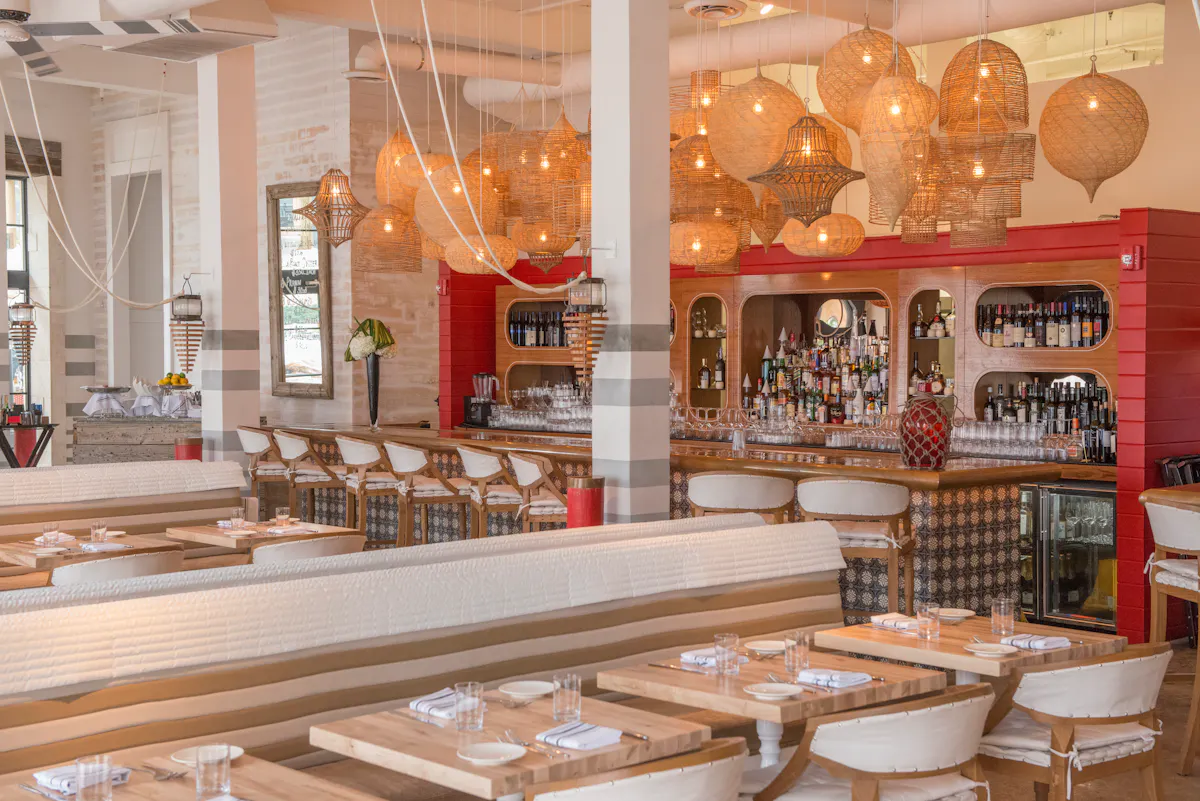 Seaspice's main dining room with tables, chairs, and a stunning bar.