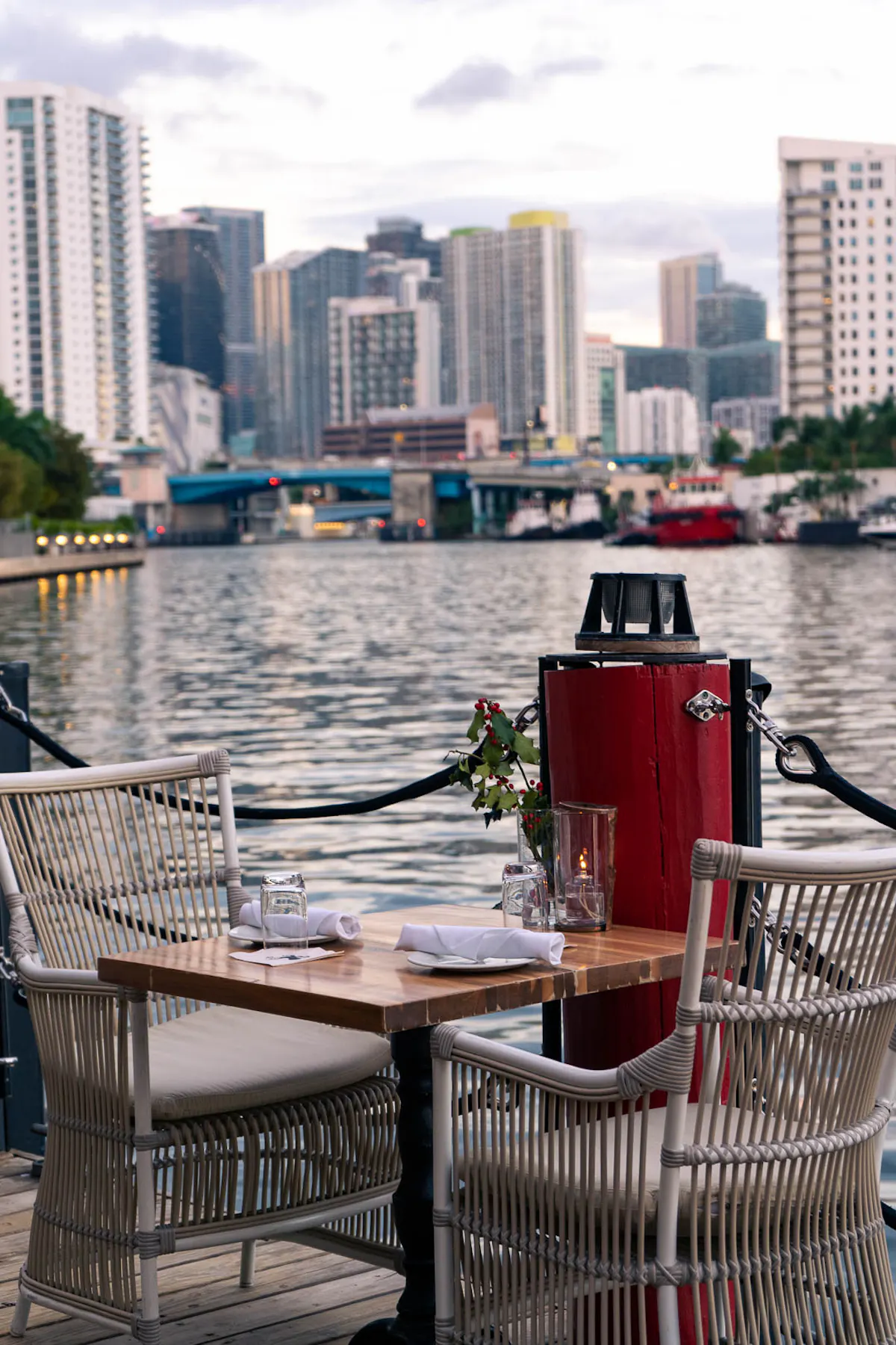 a bench next to a body of water with a city in the background