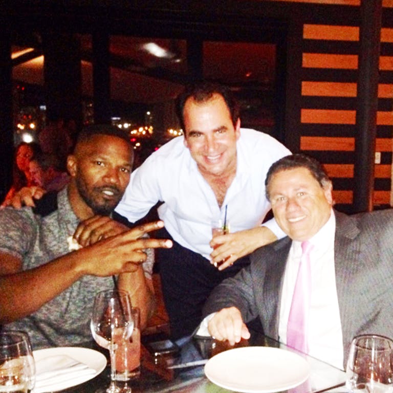 Jamie Foxx et al. sitting at a table in a restaurant