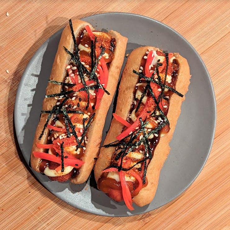 a plate with a hot dog on a wooden table