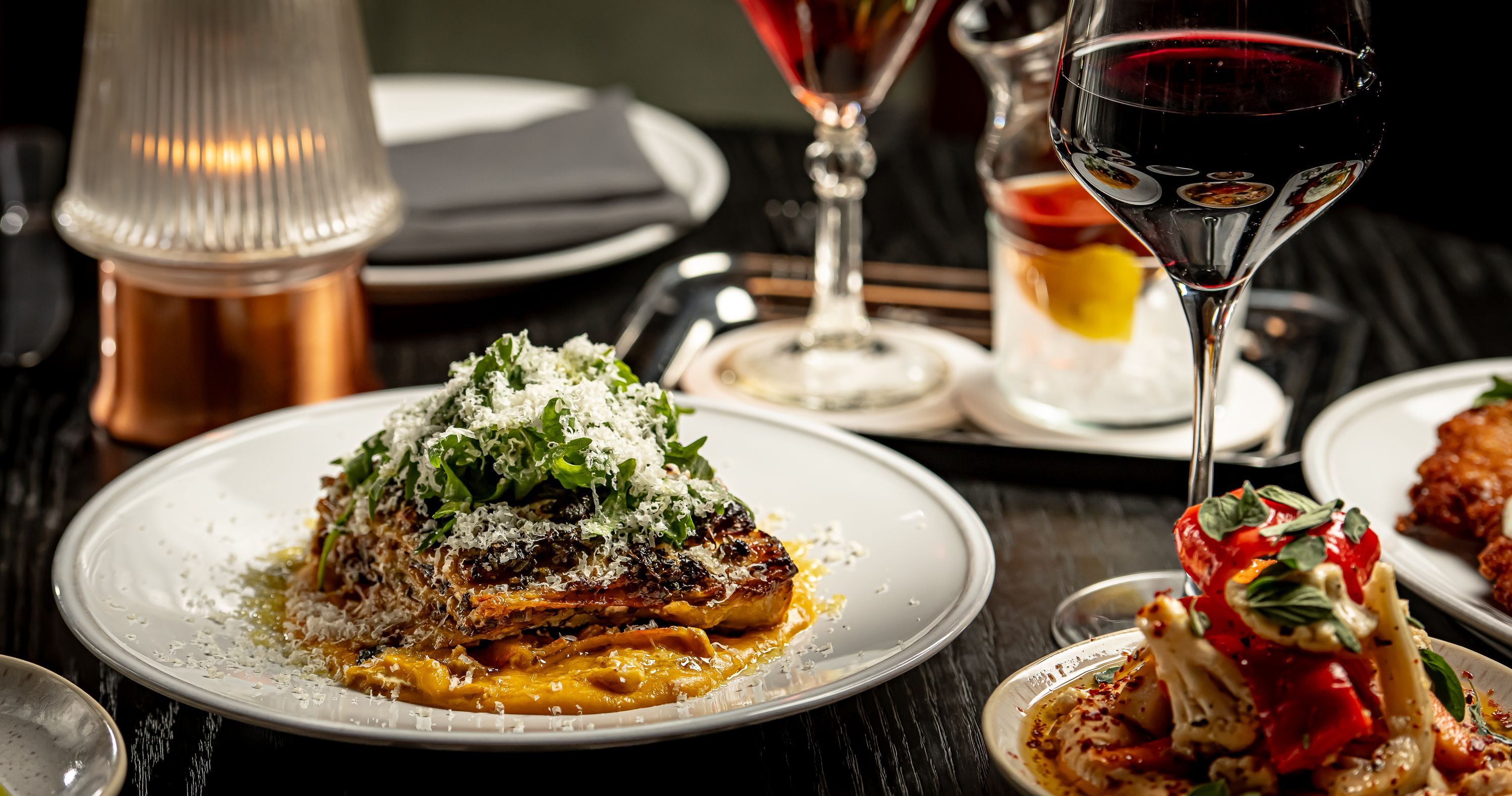 a plate of food and glasses of wine on a table
