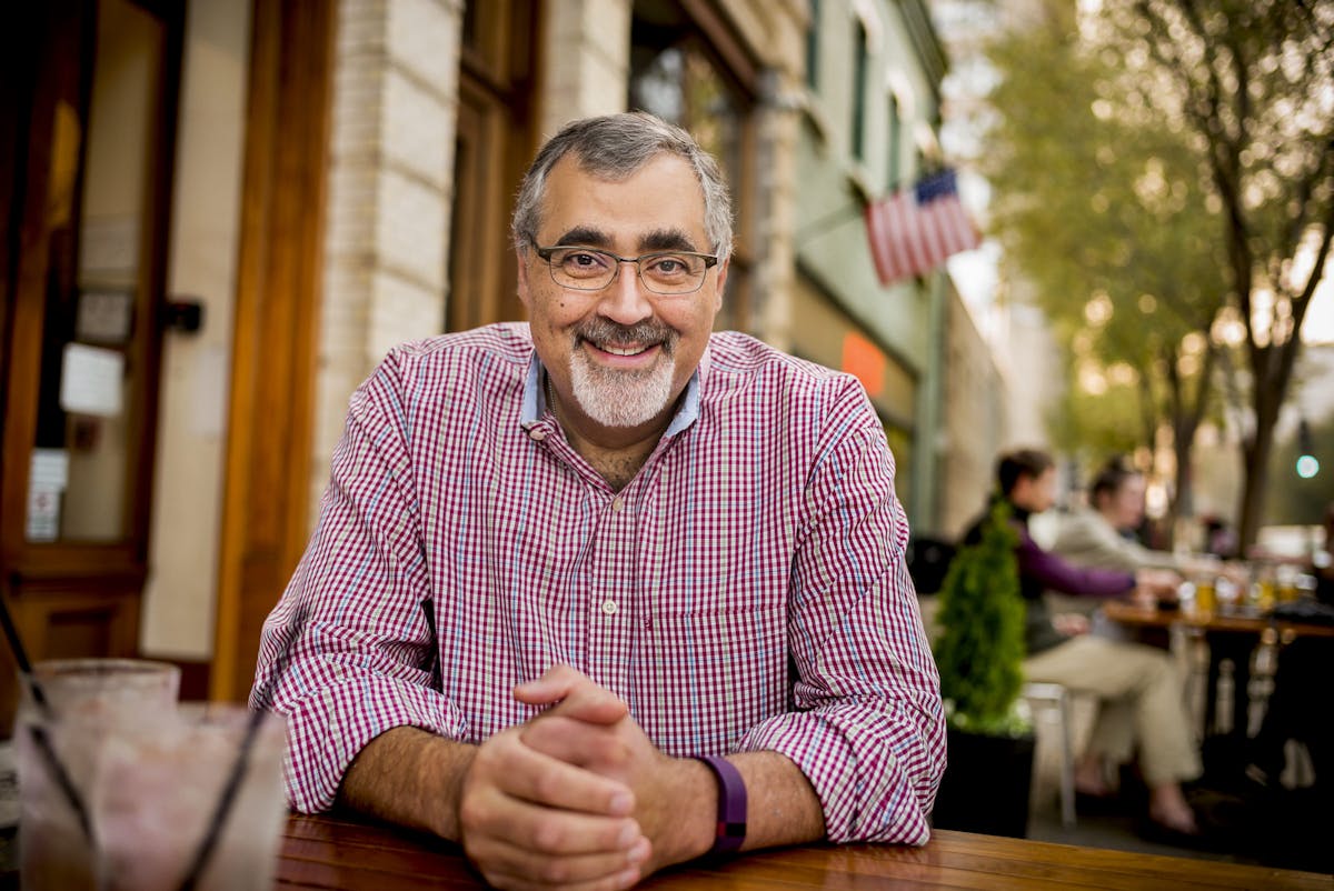 a man sitting at a table posing for a photo