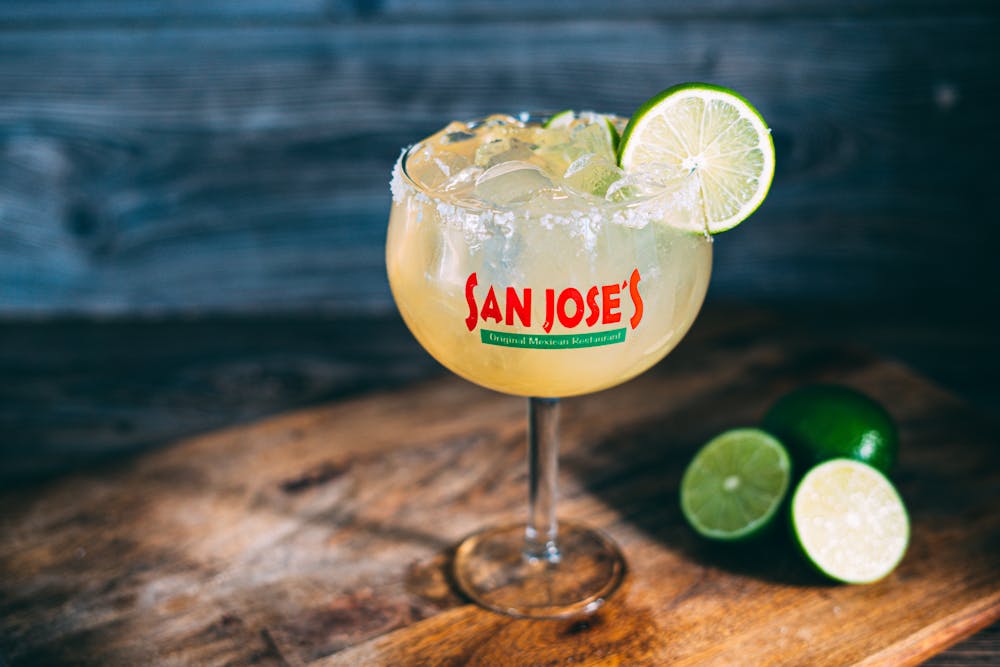 a glass of wine sitting on top of a wooden table
