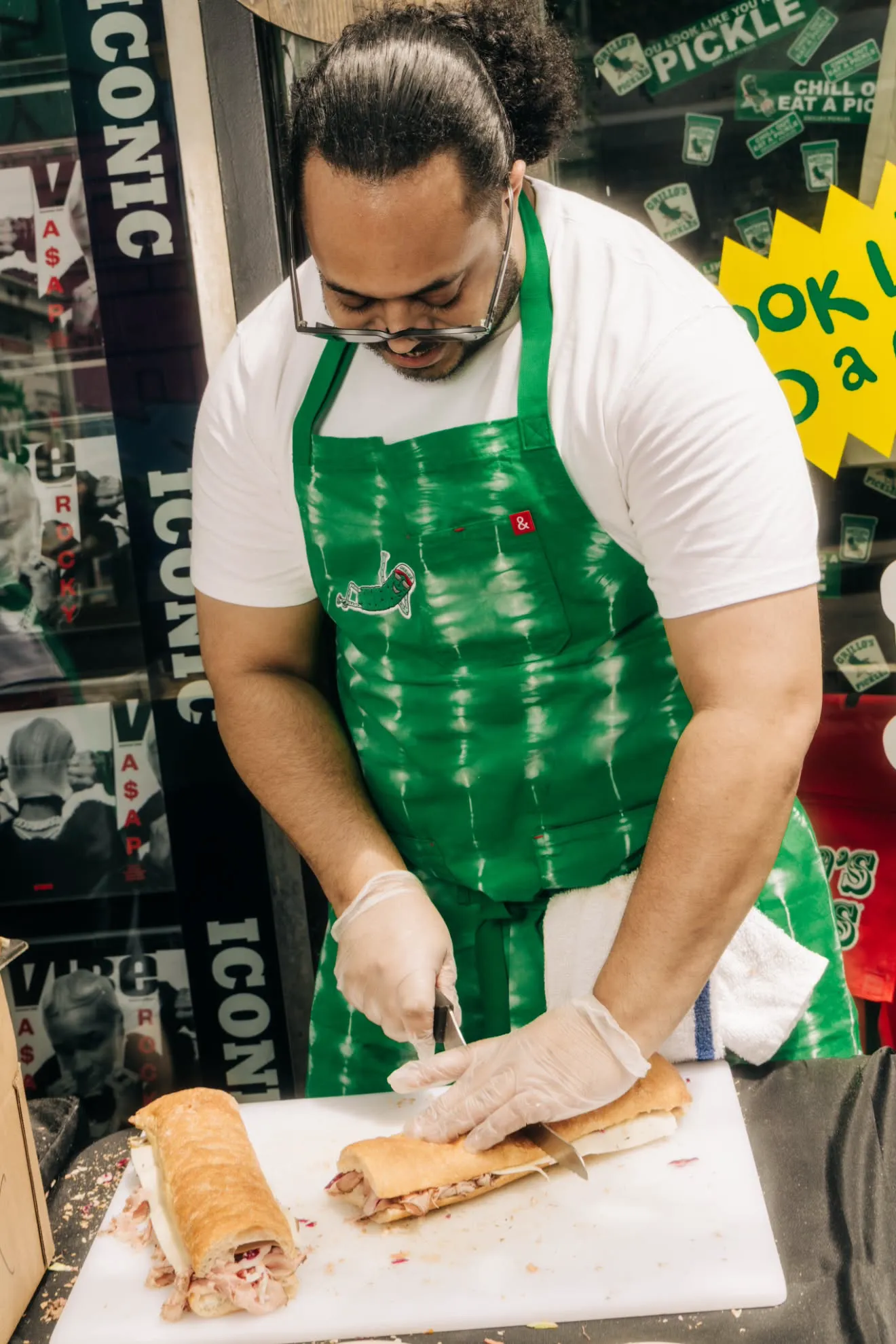 a man in a green apron cutting food