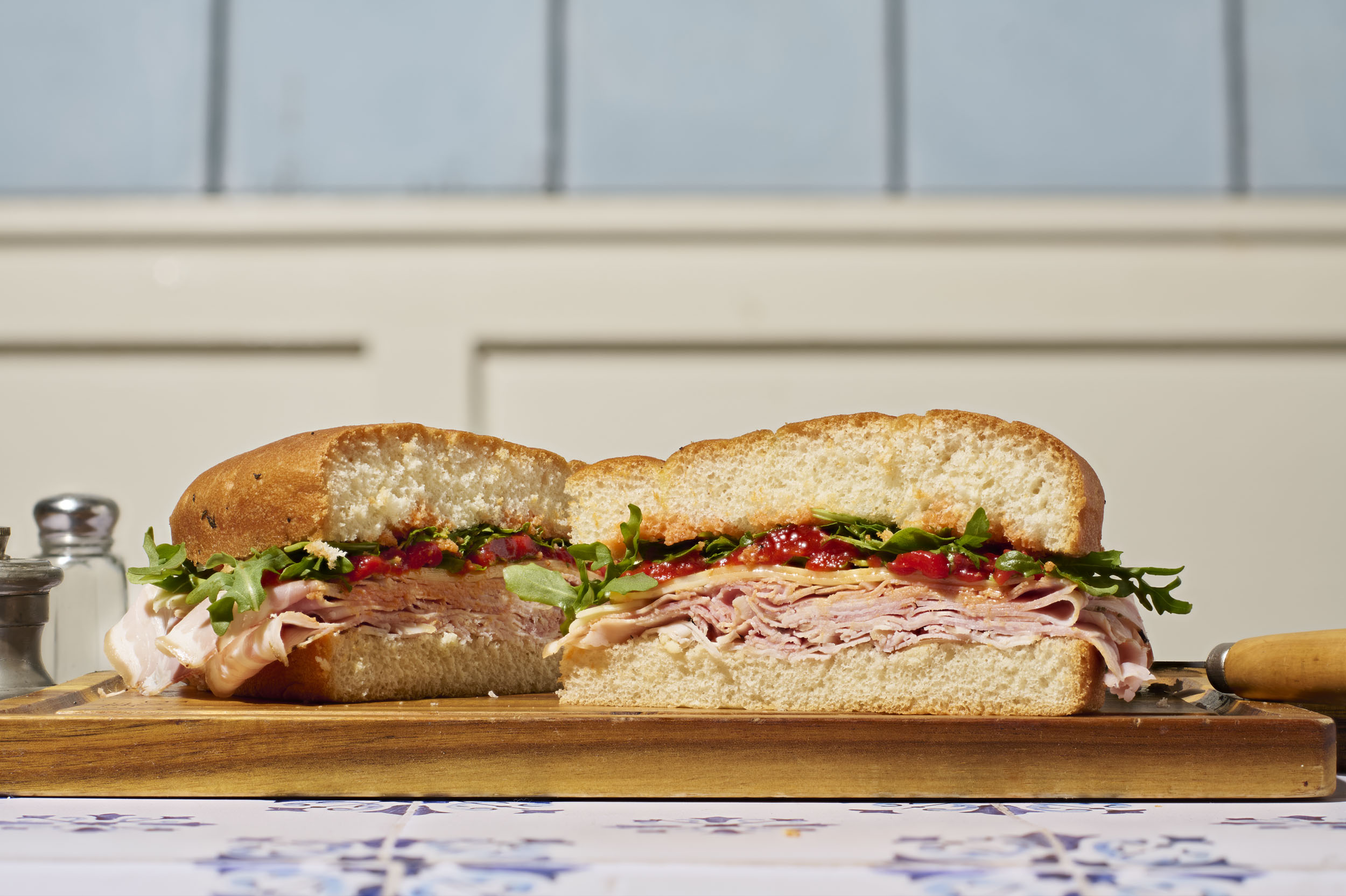 a sandwich cut in half on a wooden board