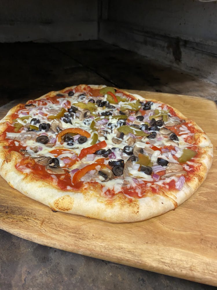 a pizza sitting on top of a wooden cutting board