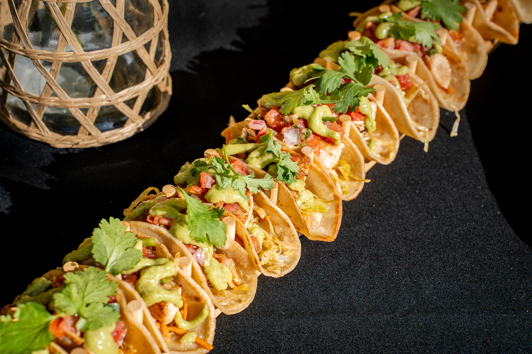 a row of tacos on a black surface
