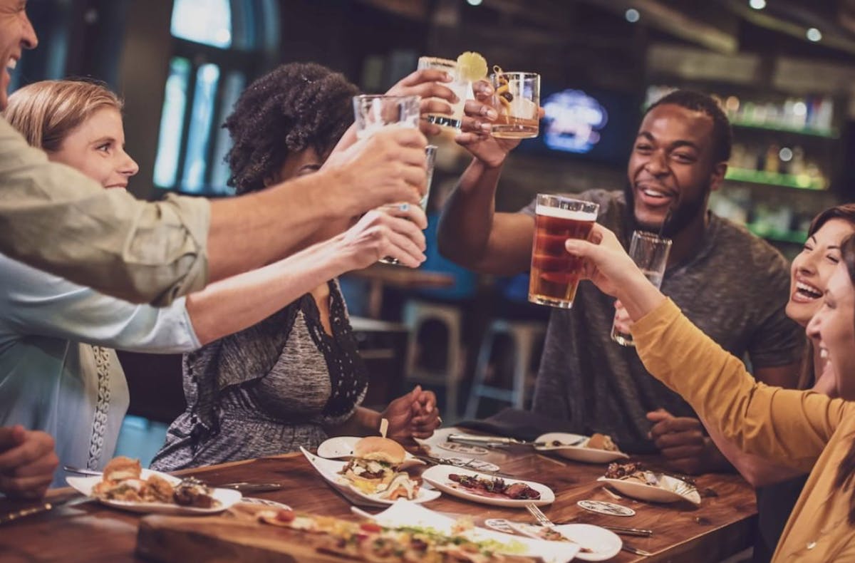 a group of people sitting at a table eating food