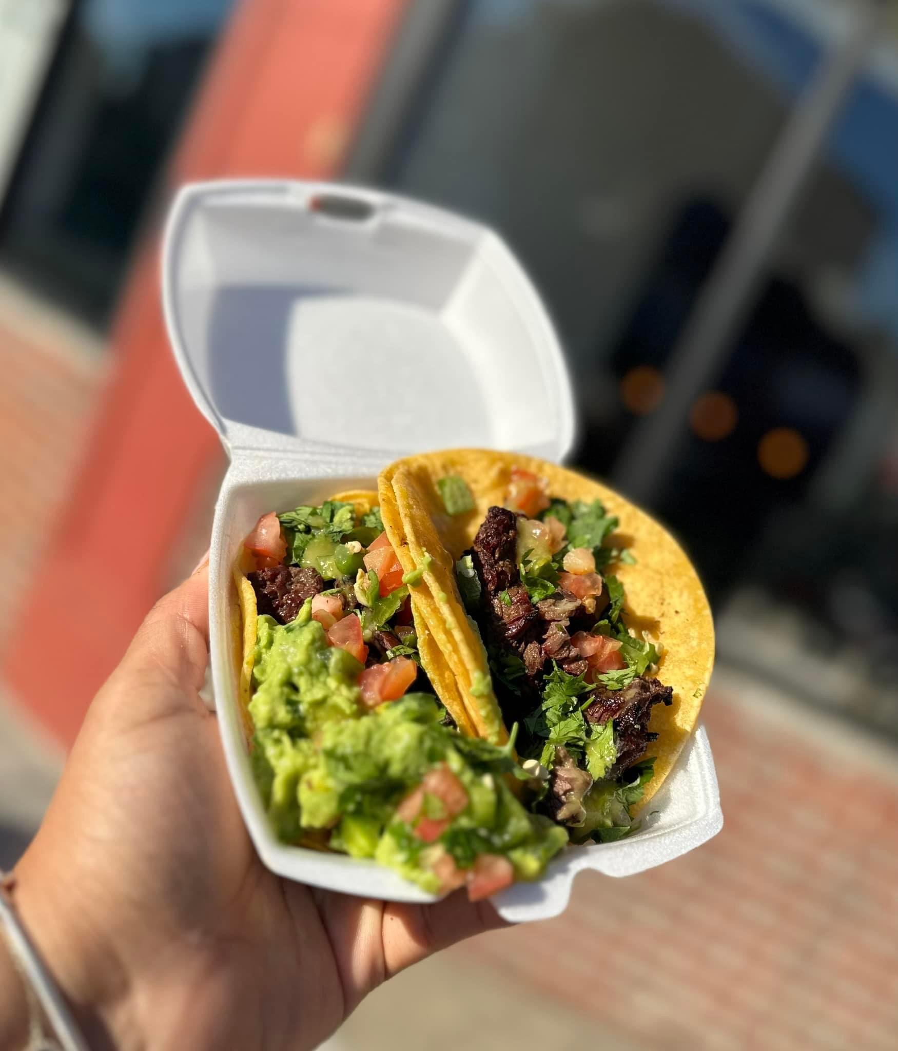 a hand holding a tray of food