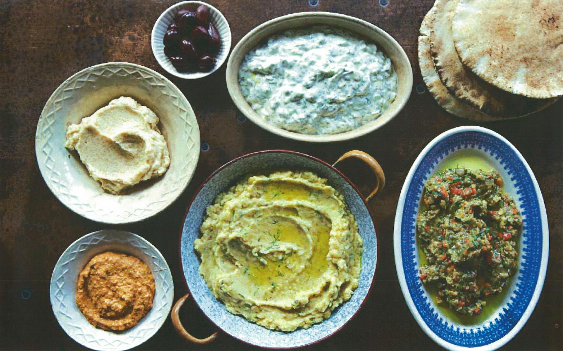 a wooden table topped with plates of food on a plate
