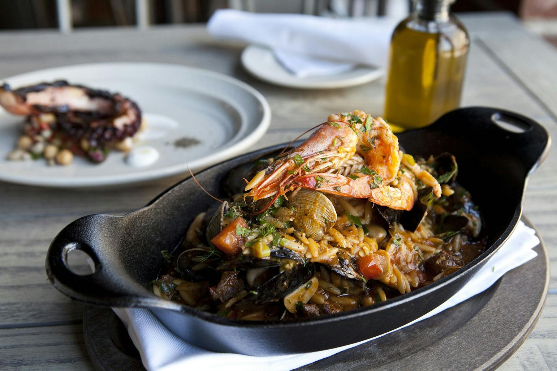 a plate of food with meat and vegetables on a wooden table