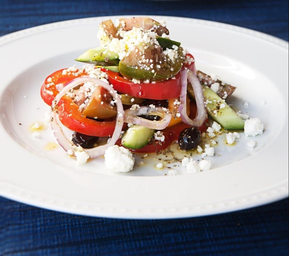 a white plate topped with meat and vegetables