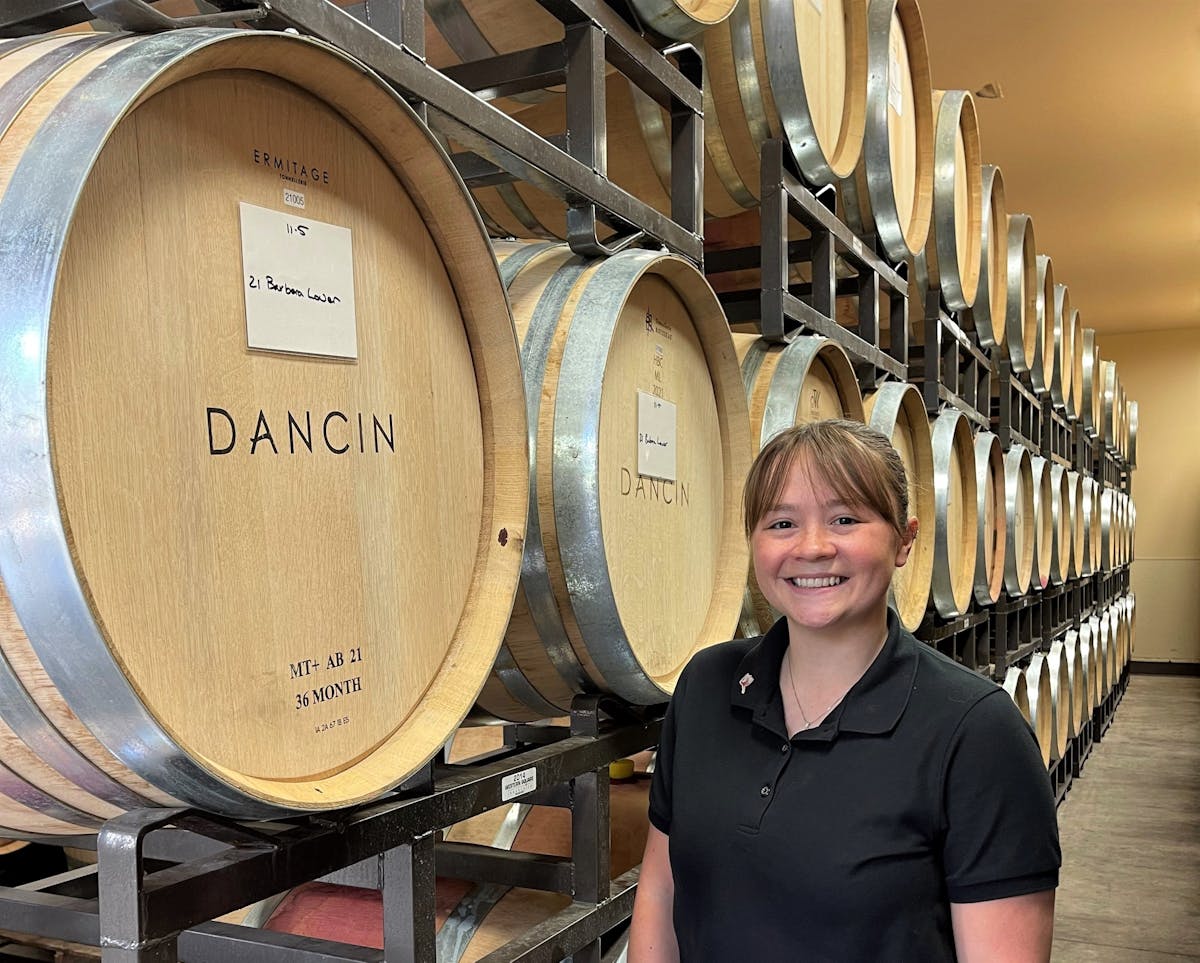 a person standing in front of a barrel