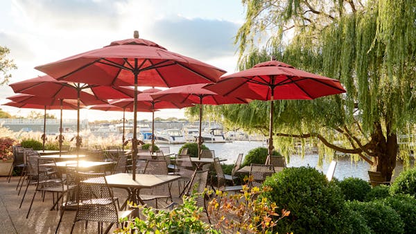 a row of lawn chairs sitting on top of a red umbrella
