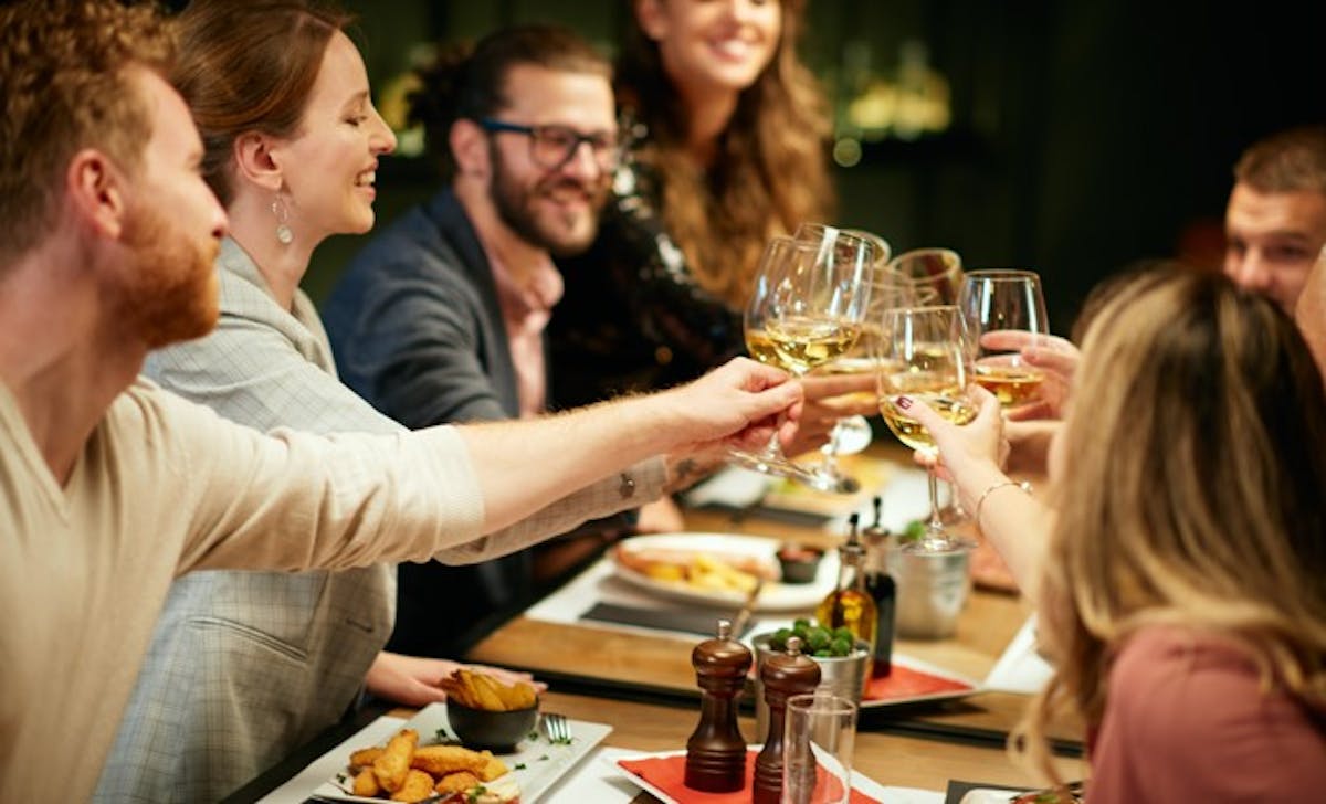 a group of people sitting at a table with wine glasses