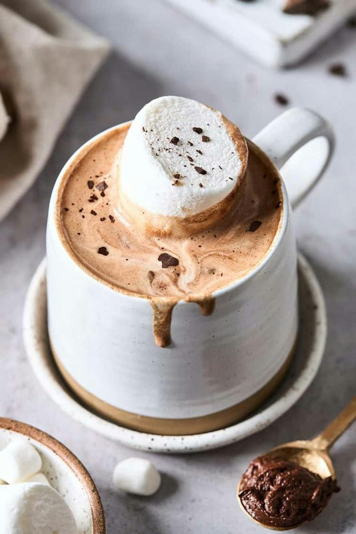 a piece of cake on a plate next to a cup of coffee